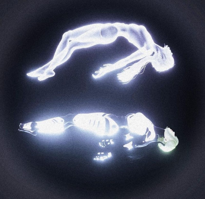 Два сияющих тела: одно лежит, другое поднимается вверх, показывая момент выхода души из физического тела.