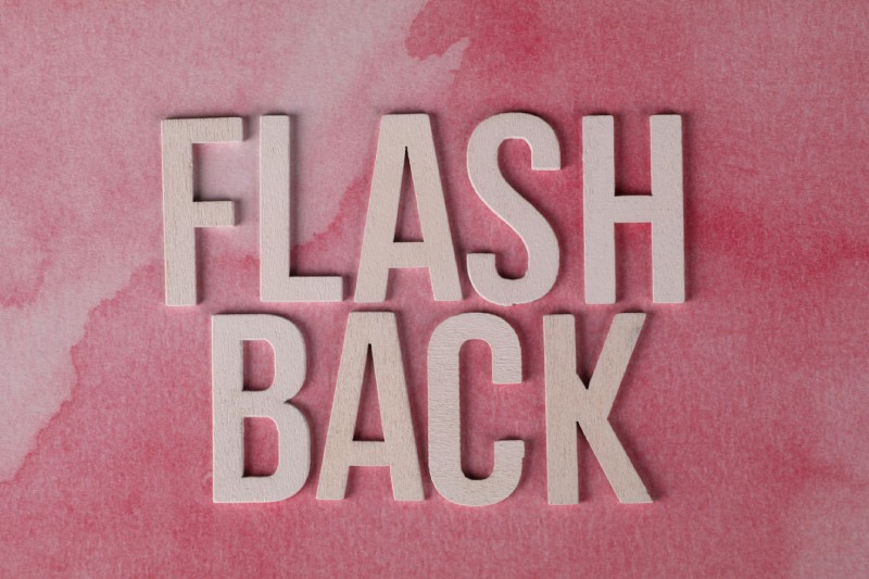 Дерев'яні літери, що складають слово «FLASHBACK» на рожевому фоні — концептуальне зображення флешбеку.